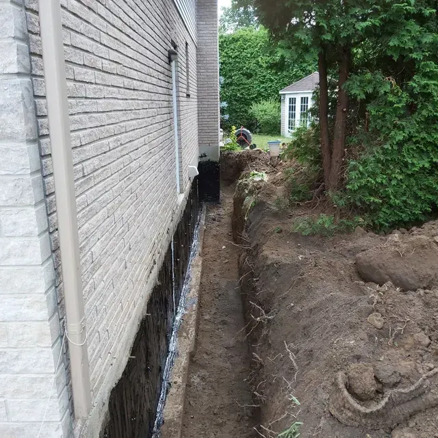 Un mur de briques avec une tranchée devant