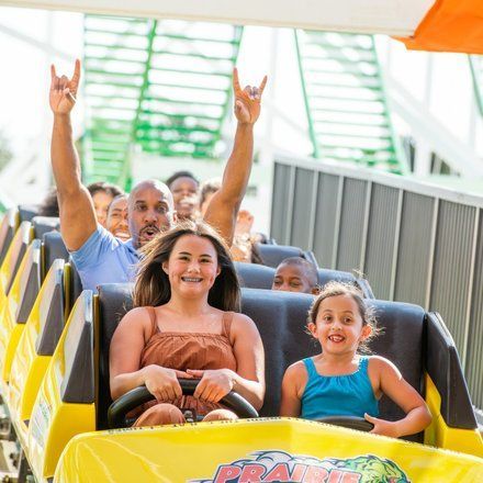 A group of people are riding a roller coaster at an amusement park.