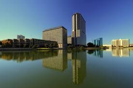 A city skyline is reflected in a body of water.