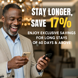 Smiling man looks at phones, ad: Stay longer, save 17% for 60+ day stays.