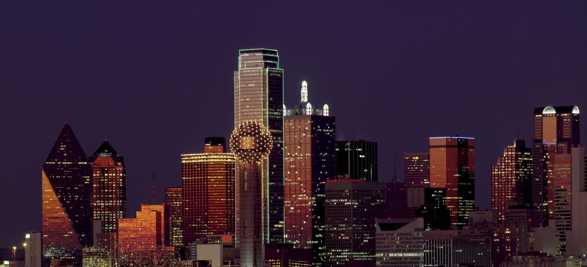 A city skyline at night with many buildings lit up