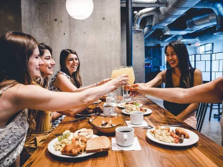 A group of women are sitting at a table eating food.