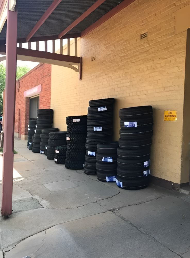 A Bunch of Tires Are Stacked on the Side of a Building — Mayne Street Auto in Gulgong, NSW