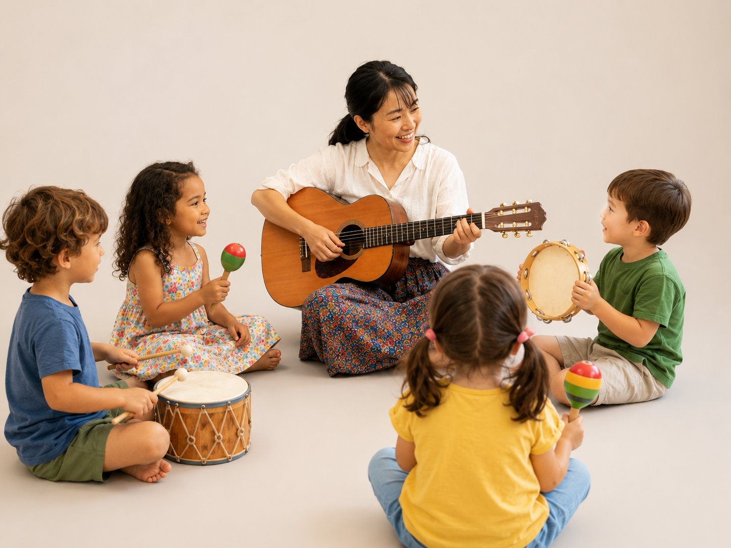 Un professeur joue de la guitare avec des enfants qui utilisent des tambours et un tambourin, disposés en cercle sur le sol.
