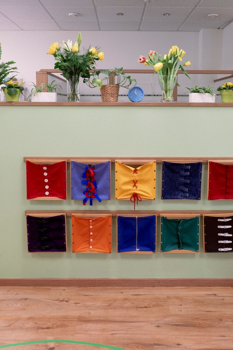 Tableau d'affichage de classe avec des pochettes en tissu colorées et des compositions florales sur le dessus