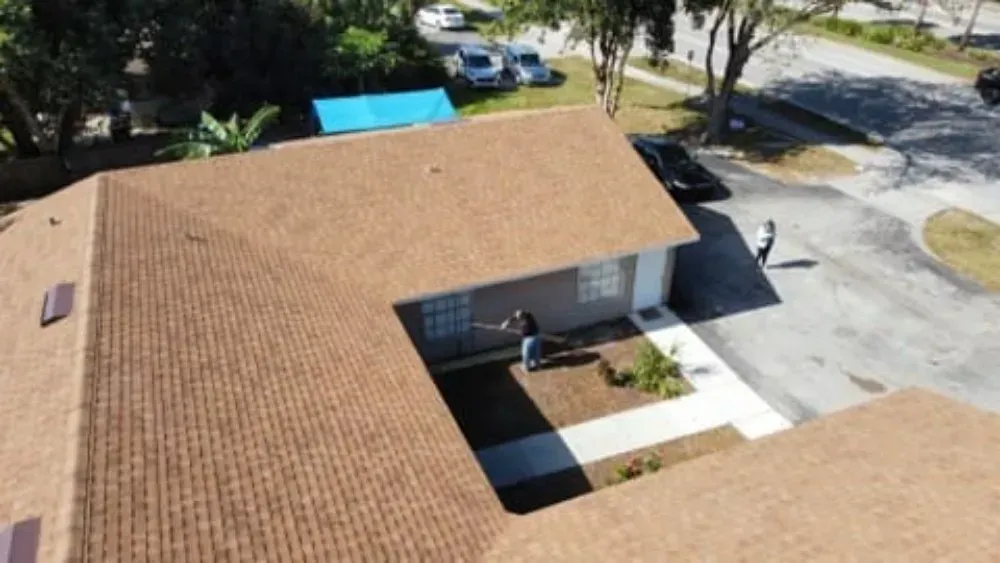 Brown roofed building with people outdoors, sunny day.