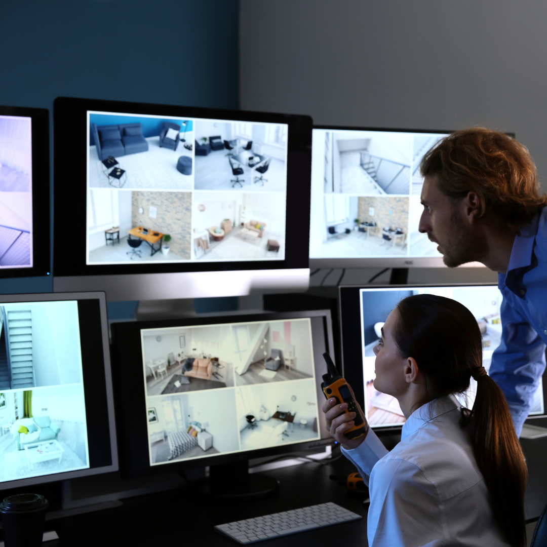 a man and a woman are looking at computer monitors