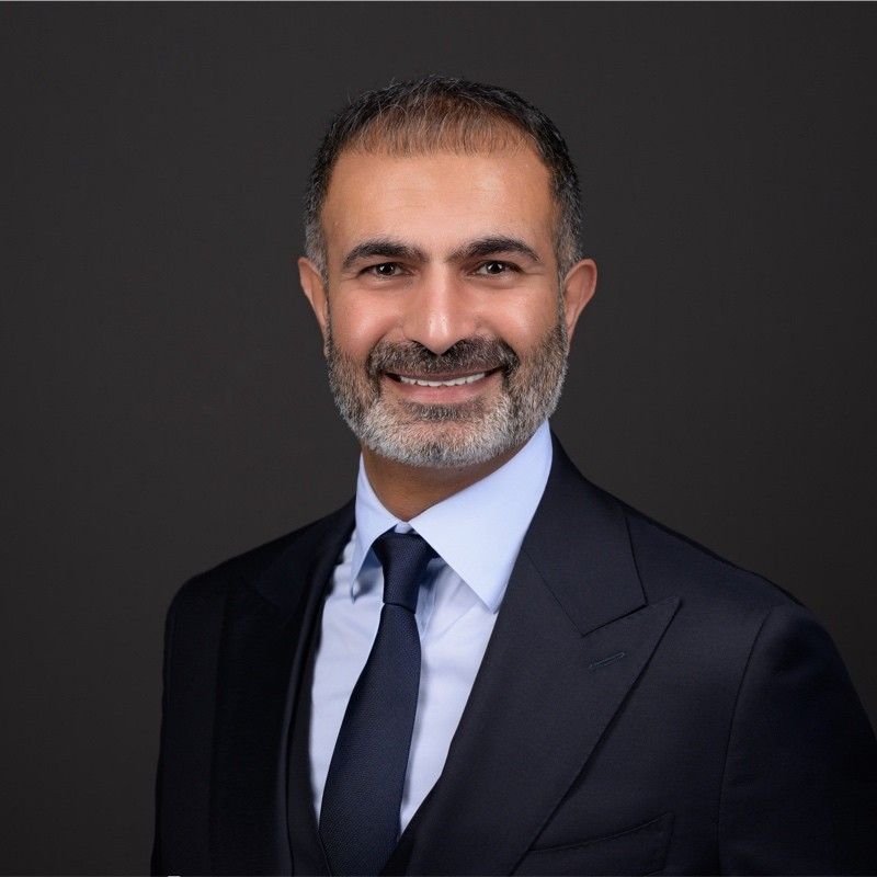 a man in a suit and tie is smiling for the camera .