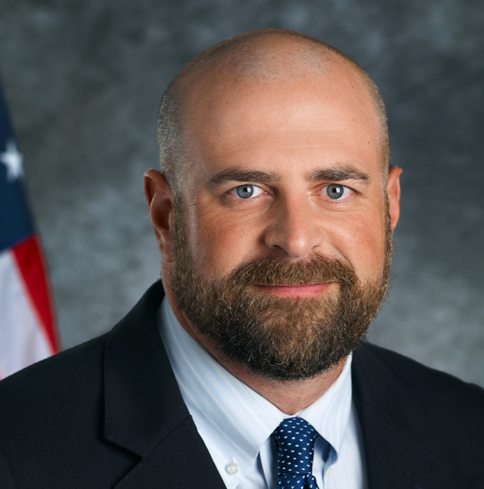 a bald man with a beard wearing a suit and tie