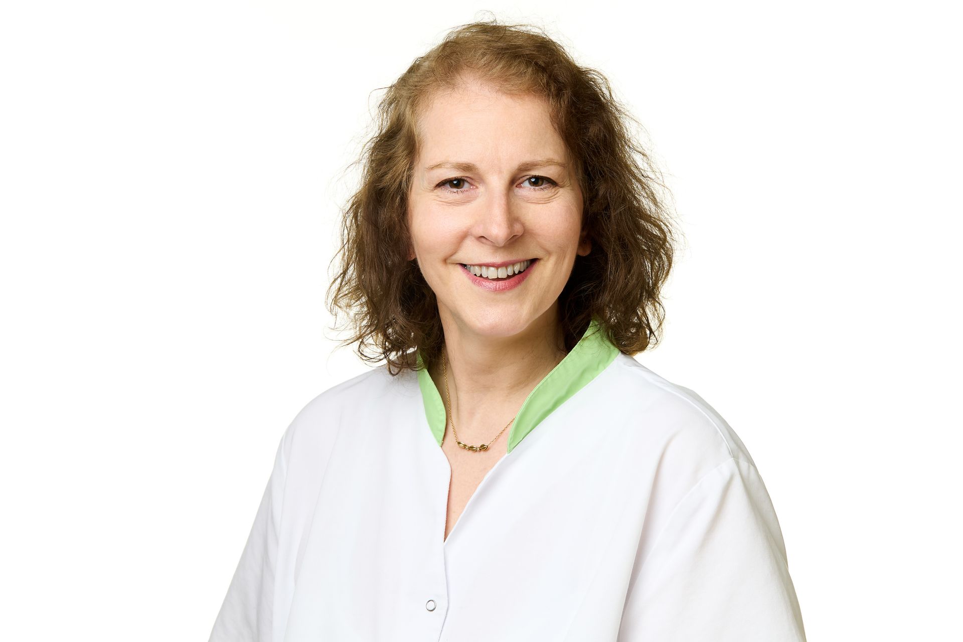 Lächelnde Frau im weissen Arztkittel mit grünem Kragen.