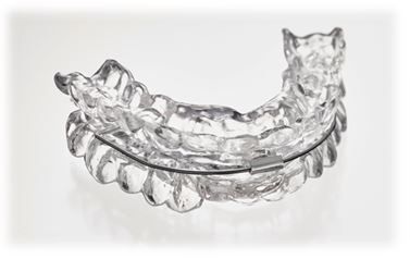 Transparente, kunststoffbasierte Mundschiene zur Behandlung von Schlafapnoe auf weißer Oberfläche.