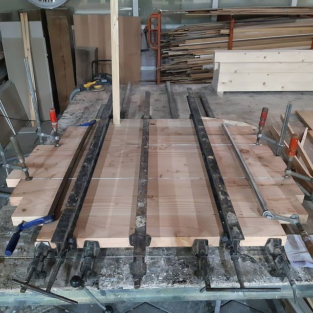 Een houten tafel met een heleboel klemmen erop