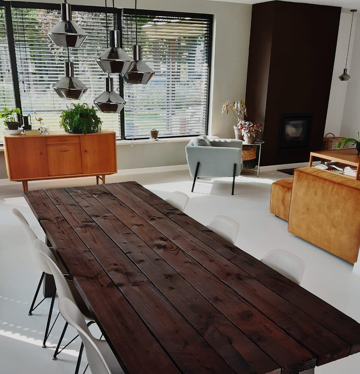 Een woonkamer met een houten tafel bewerkt volgens shou sugi ban methode en stoelen