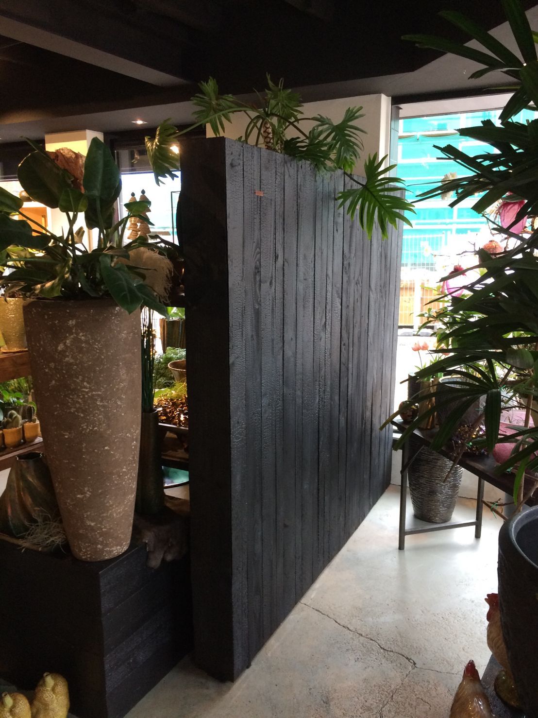 Een kamer met veel potplanten en een houten shou sugi ban muur