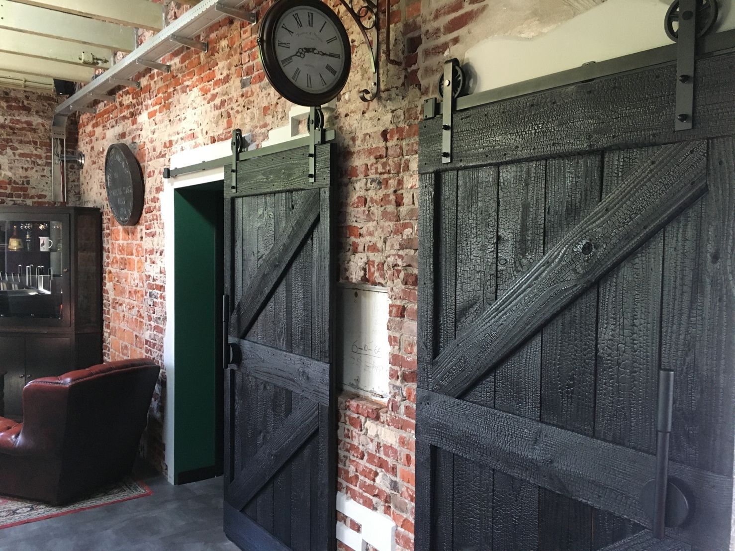 Een kamer met een klok aan de muur en Shou sugi Ban schuifdeuren