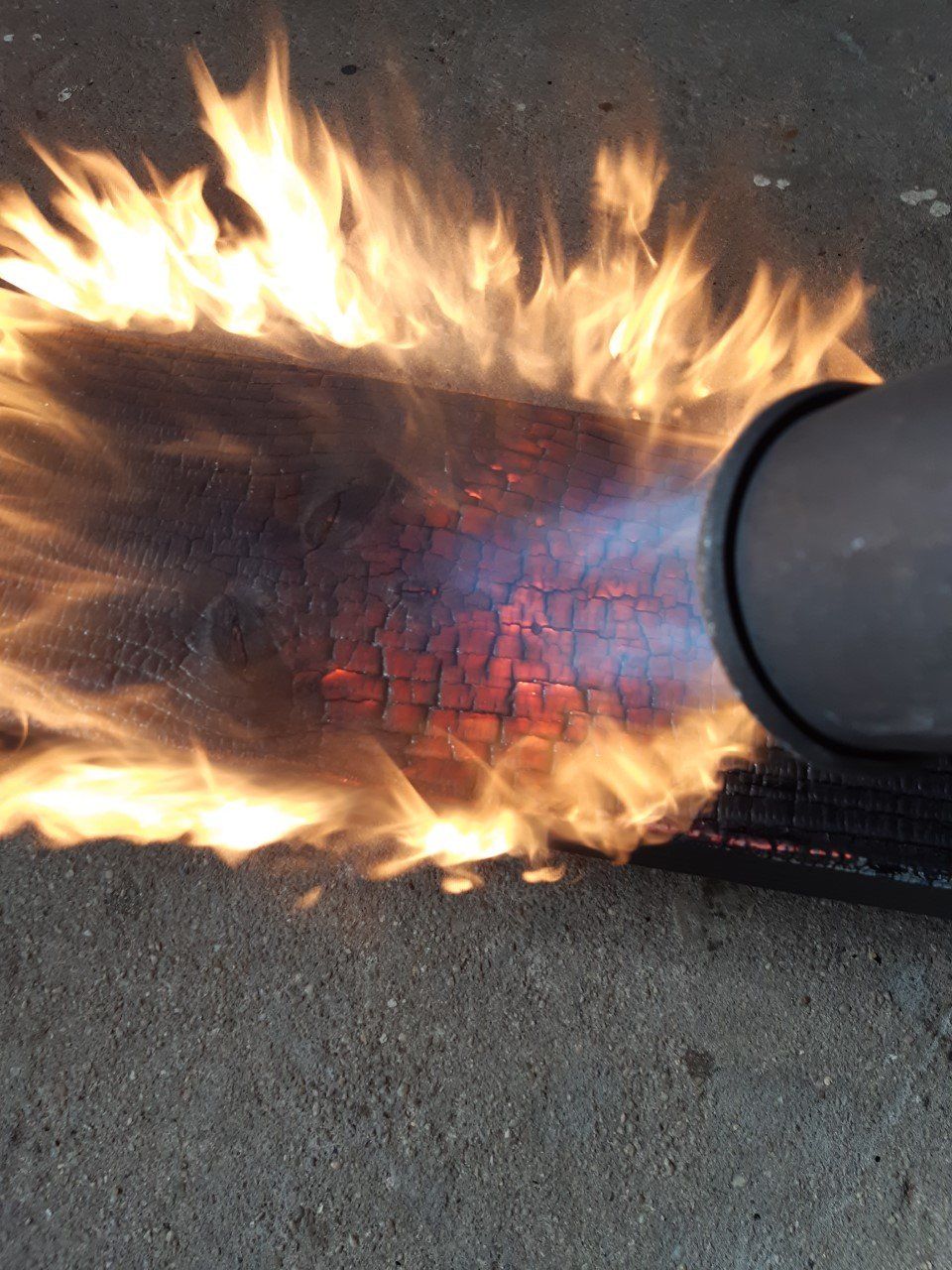 Er komt een vlam uit een pijp op de grond