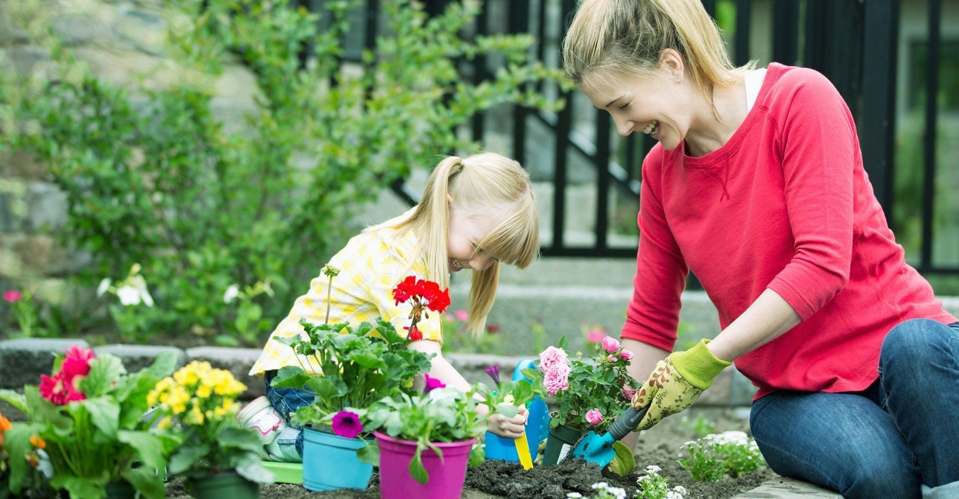 A lady gardening with a kid