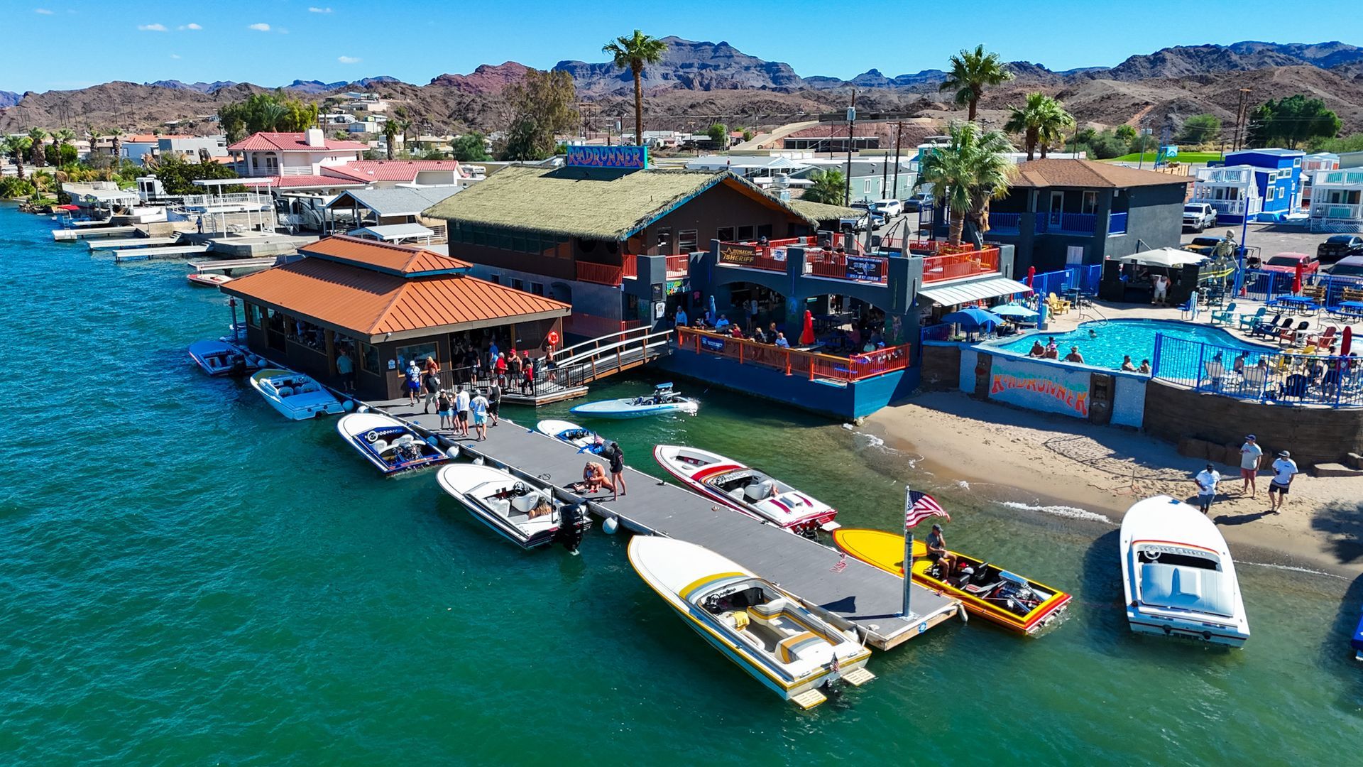 A group of boats are docked at a marina next to a building.