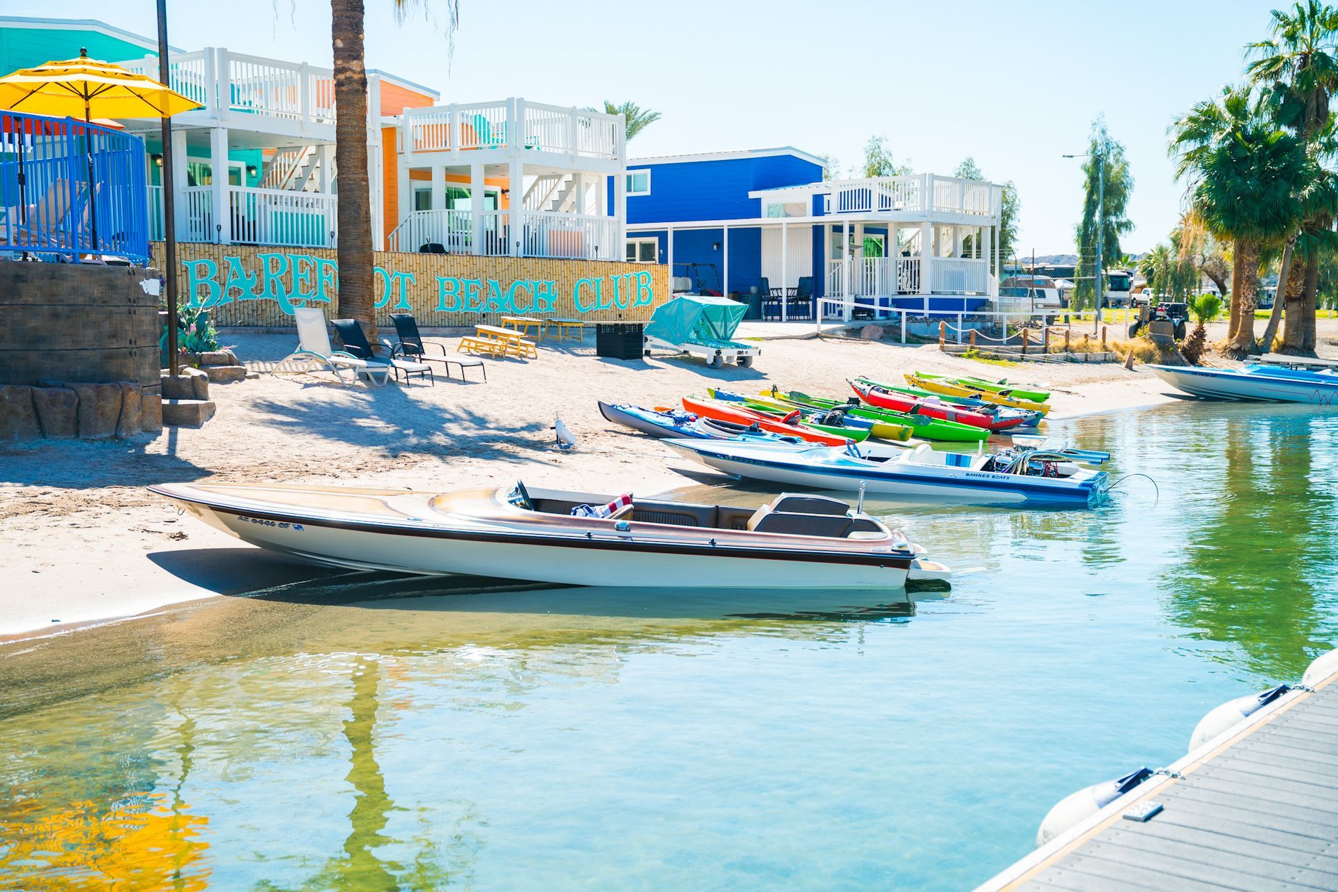 A group of boats are sitting on the shore of a lake.