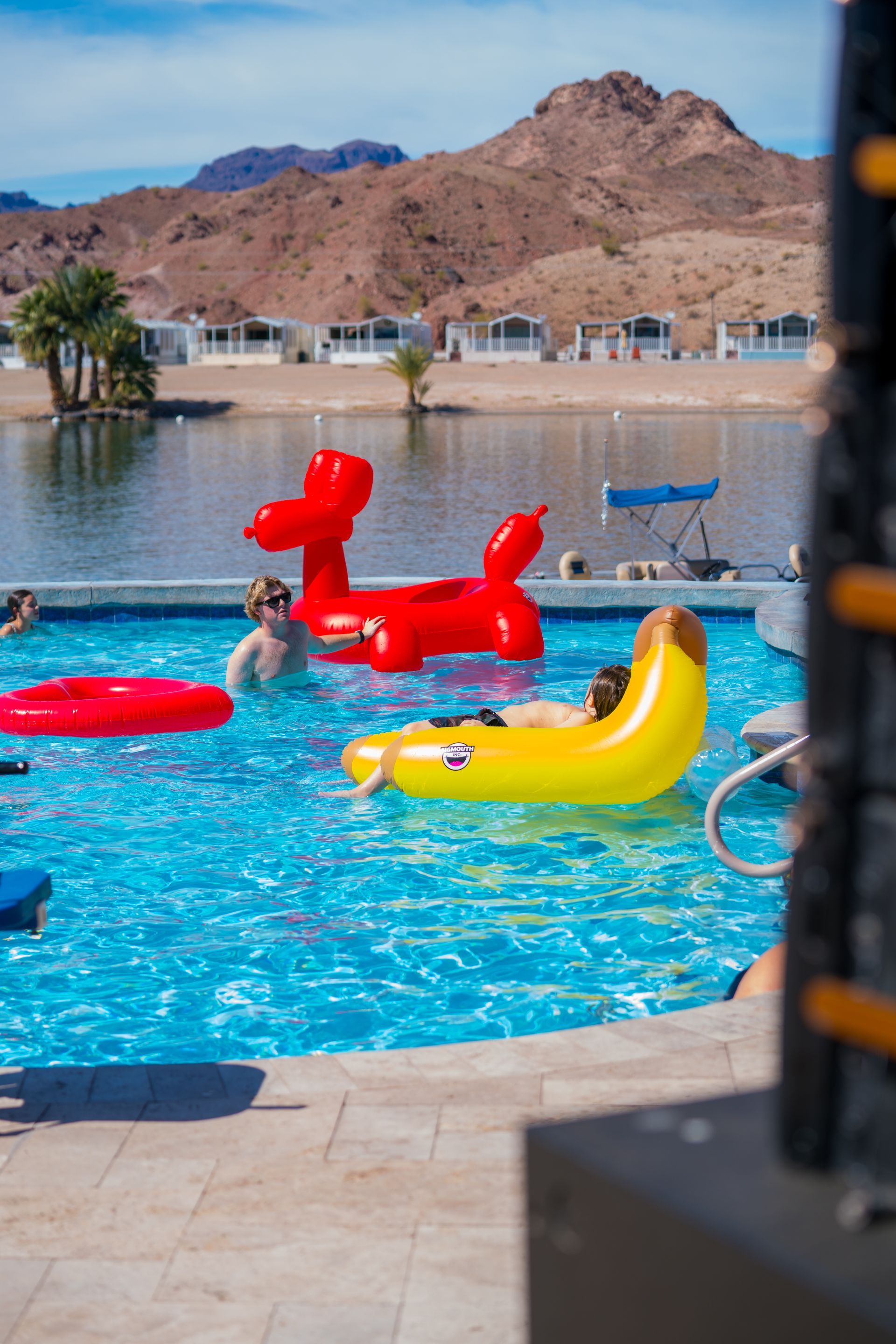An aerial view of a large swimming pool surrounded by chairs and umbrellas.