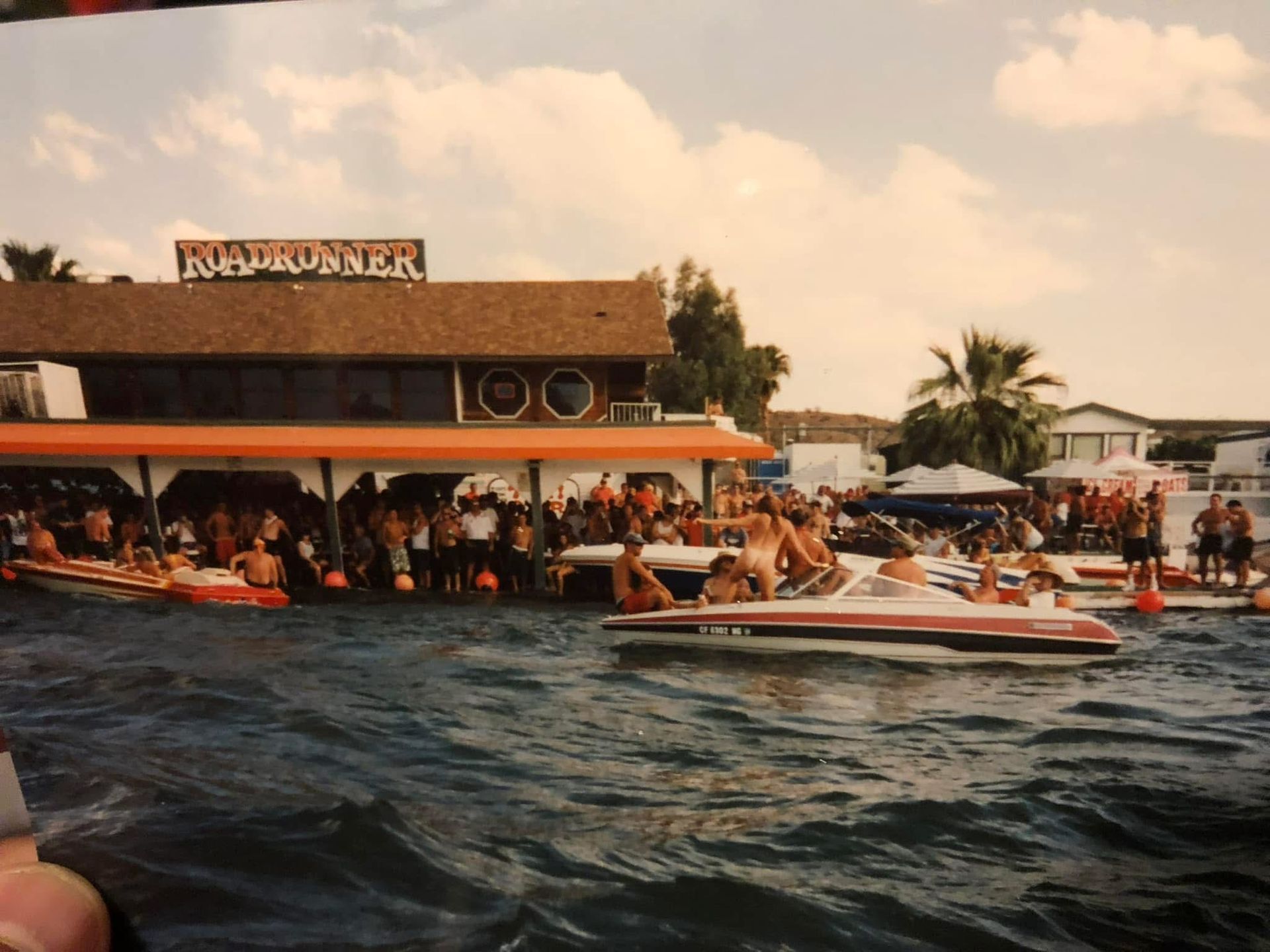 A group of people in boats in front of a building that says rio runner