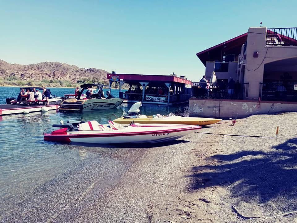 Several boats are docked on the shore of a lake