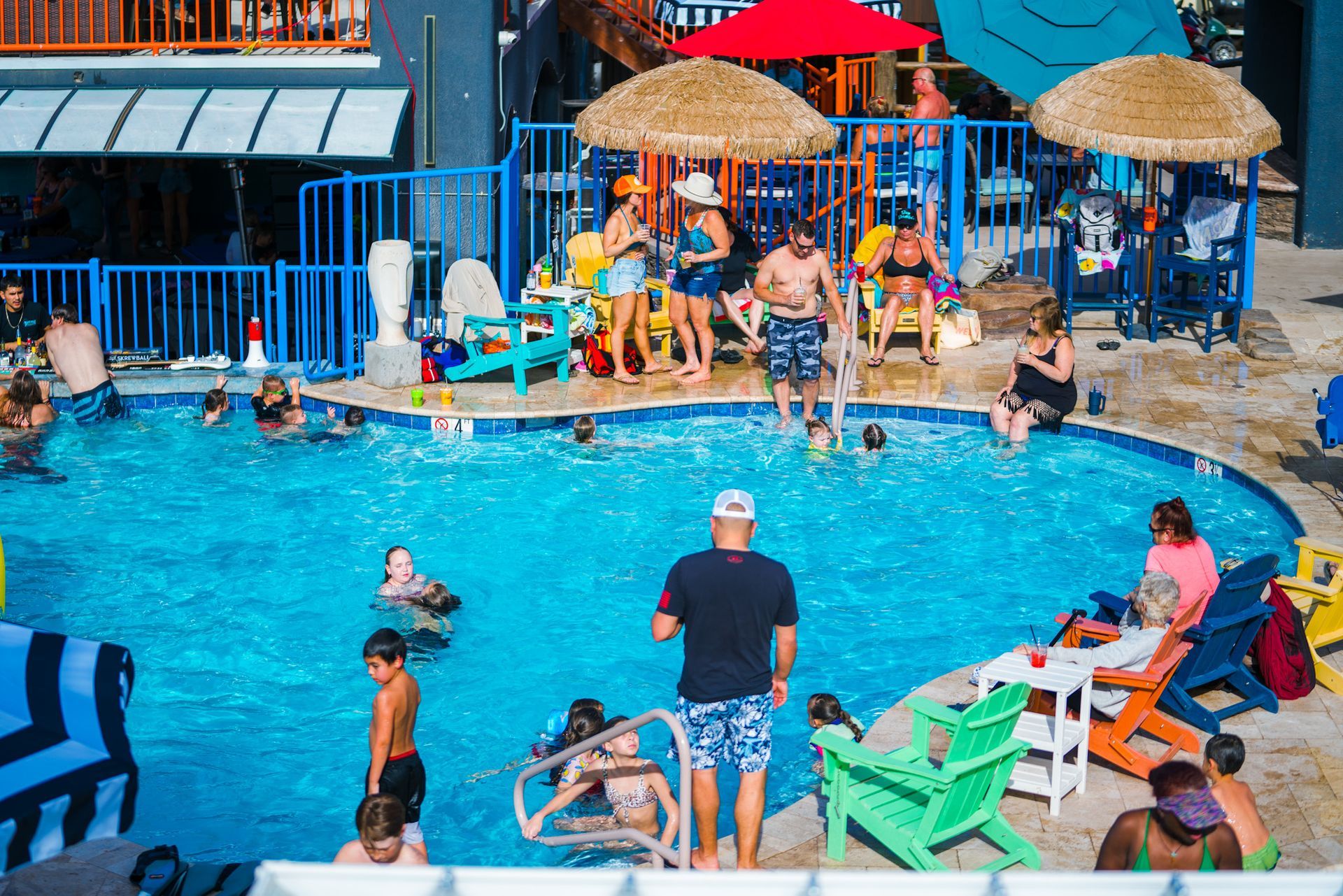 An aerial view of a large swimming pool surrounded by chairs and umbrellas.