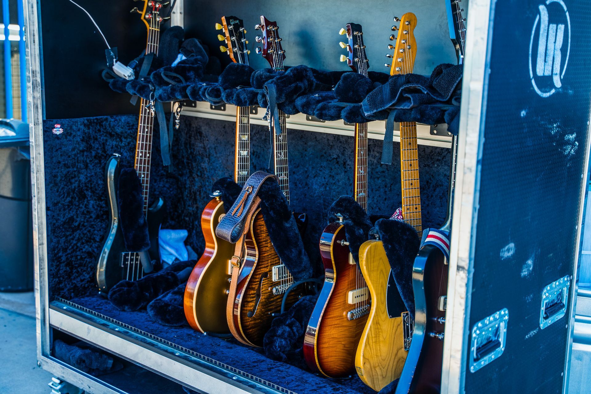 A bunch of guitars are lined up in a case