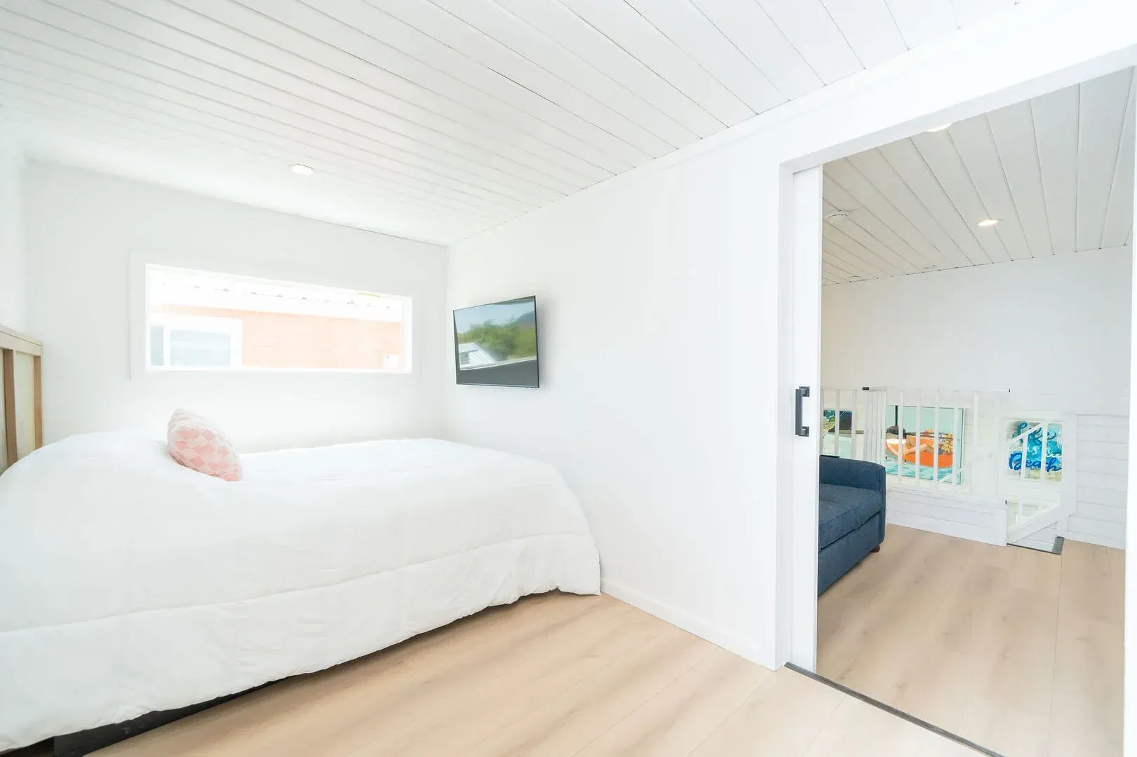 A bedroom with a bed and a television on the wall.