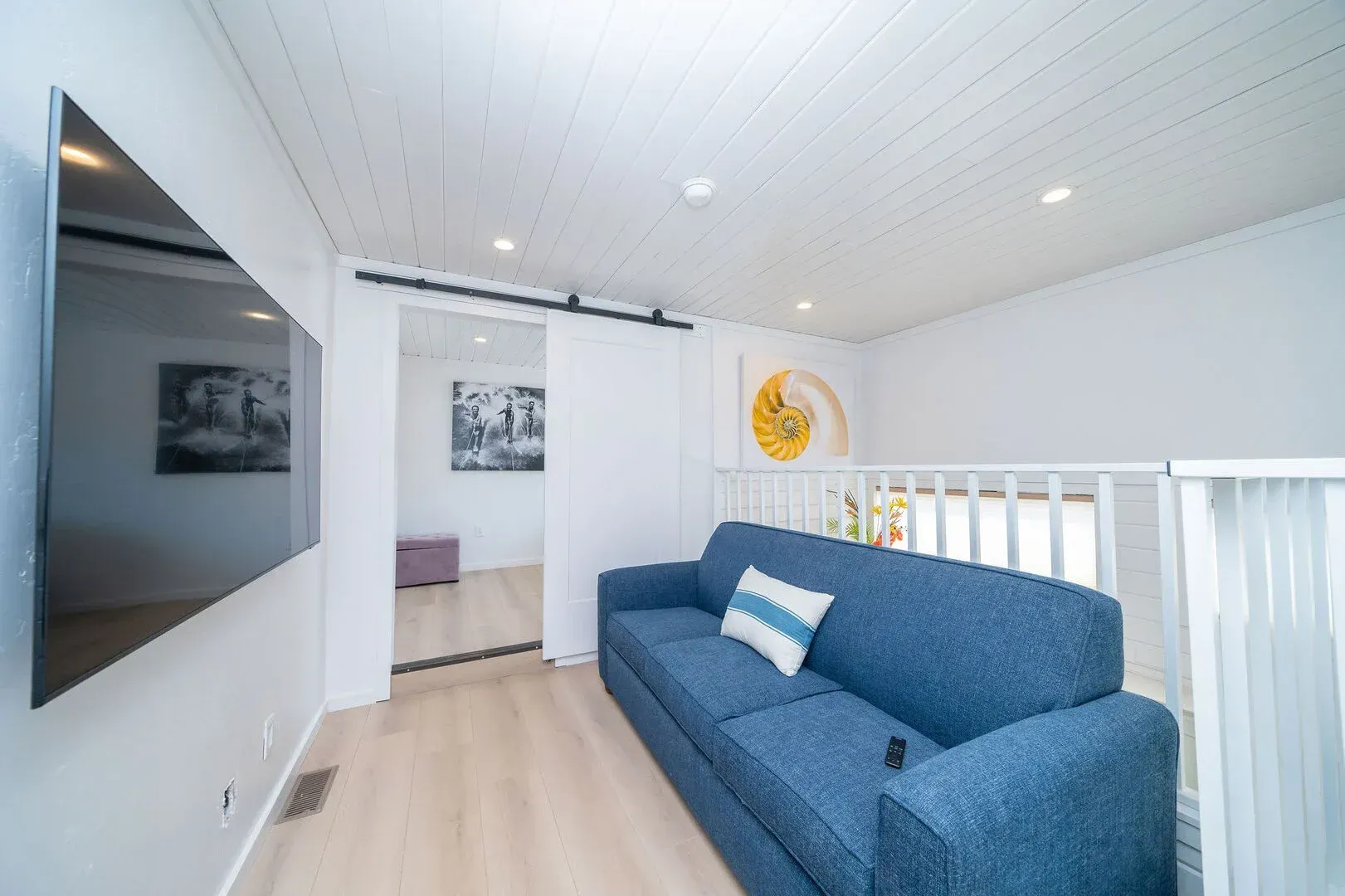 A living room with a blue couch and a flat screen tv.