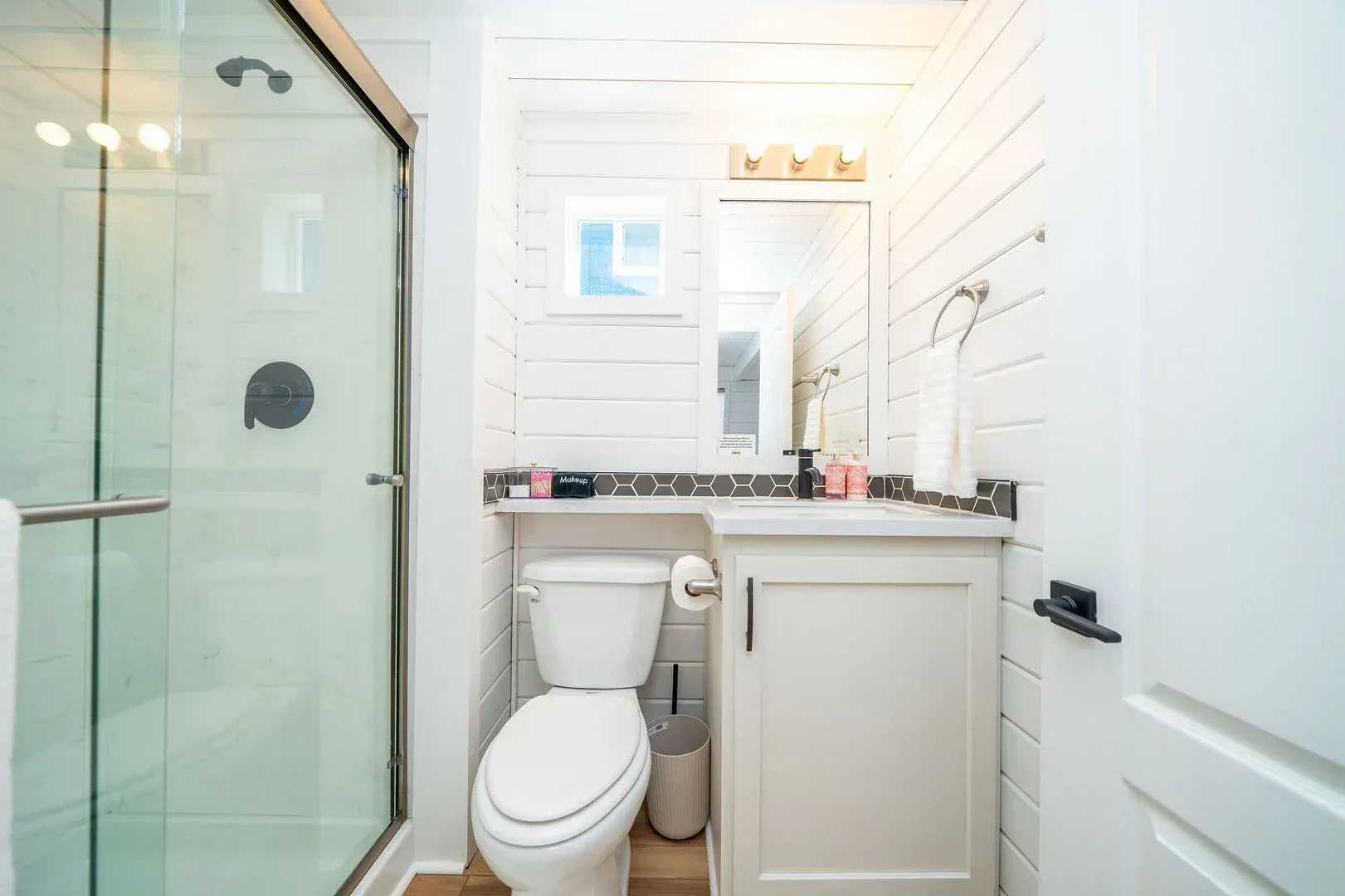 A bathroom with a toilet , sink and shower.