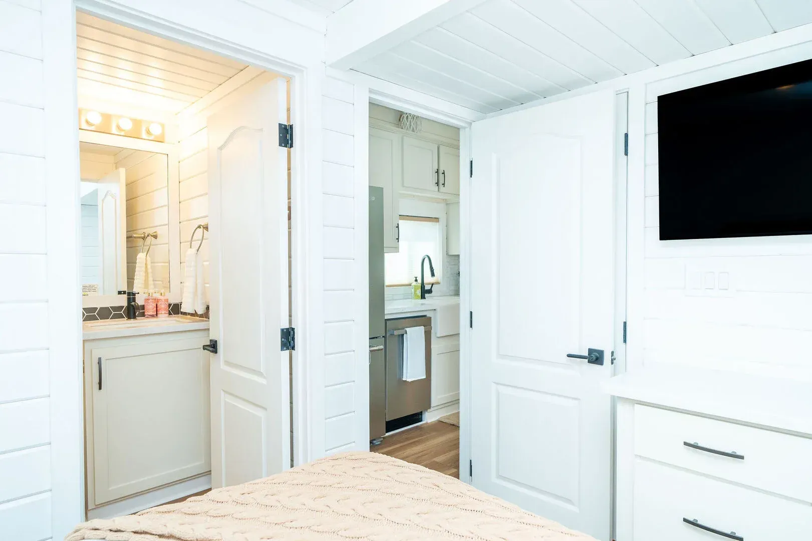 A bedroom with a bed , television , and bathroom.
