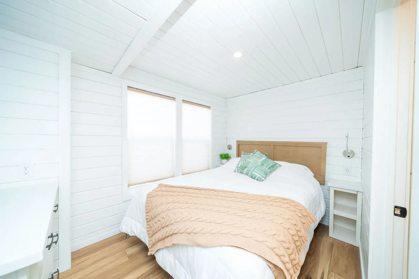 A bedroom with a bed , nightstand , and window.