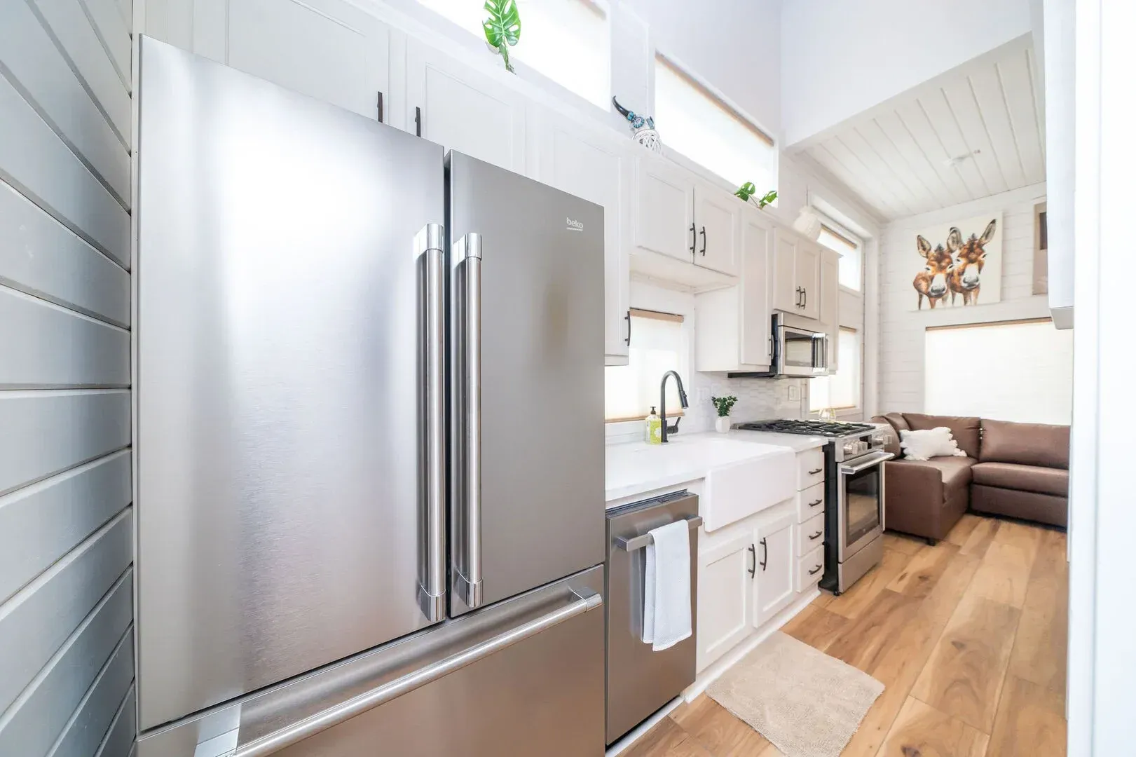 A kitchen with stainless steel appliances and white cabinets.