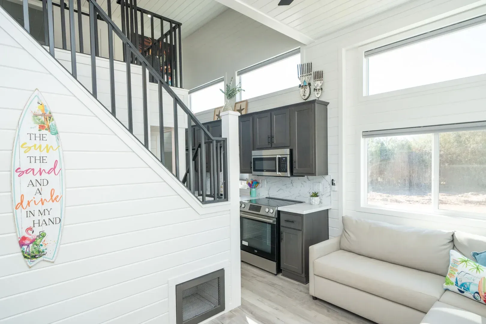 A living room with a couch and stairs leading to a kitchen.