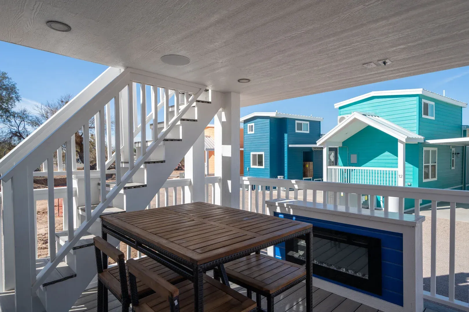 A deck with a table and chairs and stairs leading up to it
