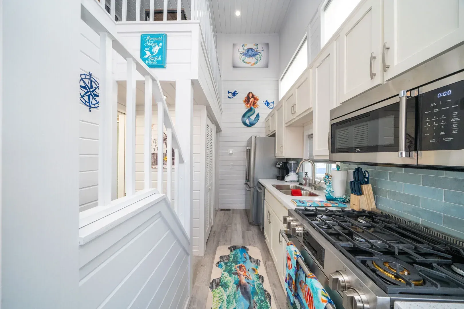 A kitchen with a stove , microwave , refrigerator and sink.