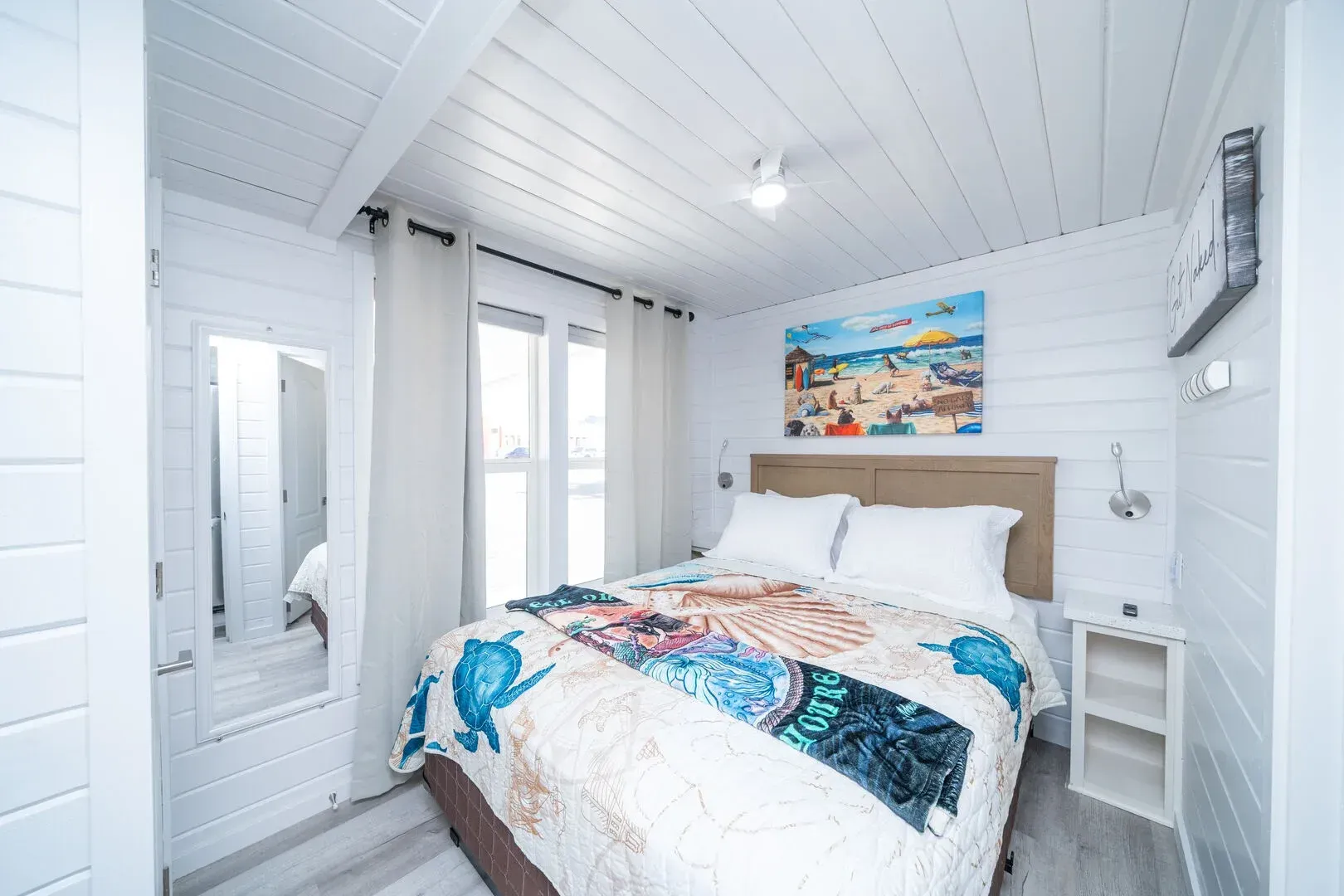 A bedroom with a king size bed and a painting on the wall.