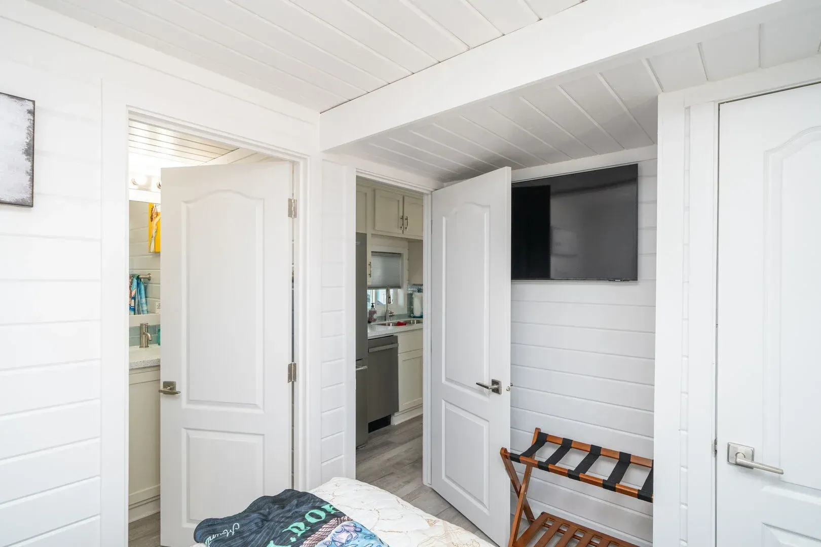 A bedroom with a bed and a television on the wall.