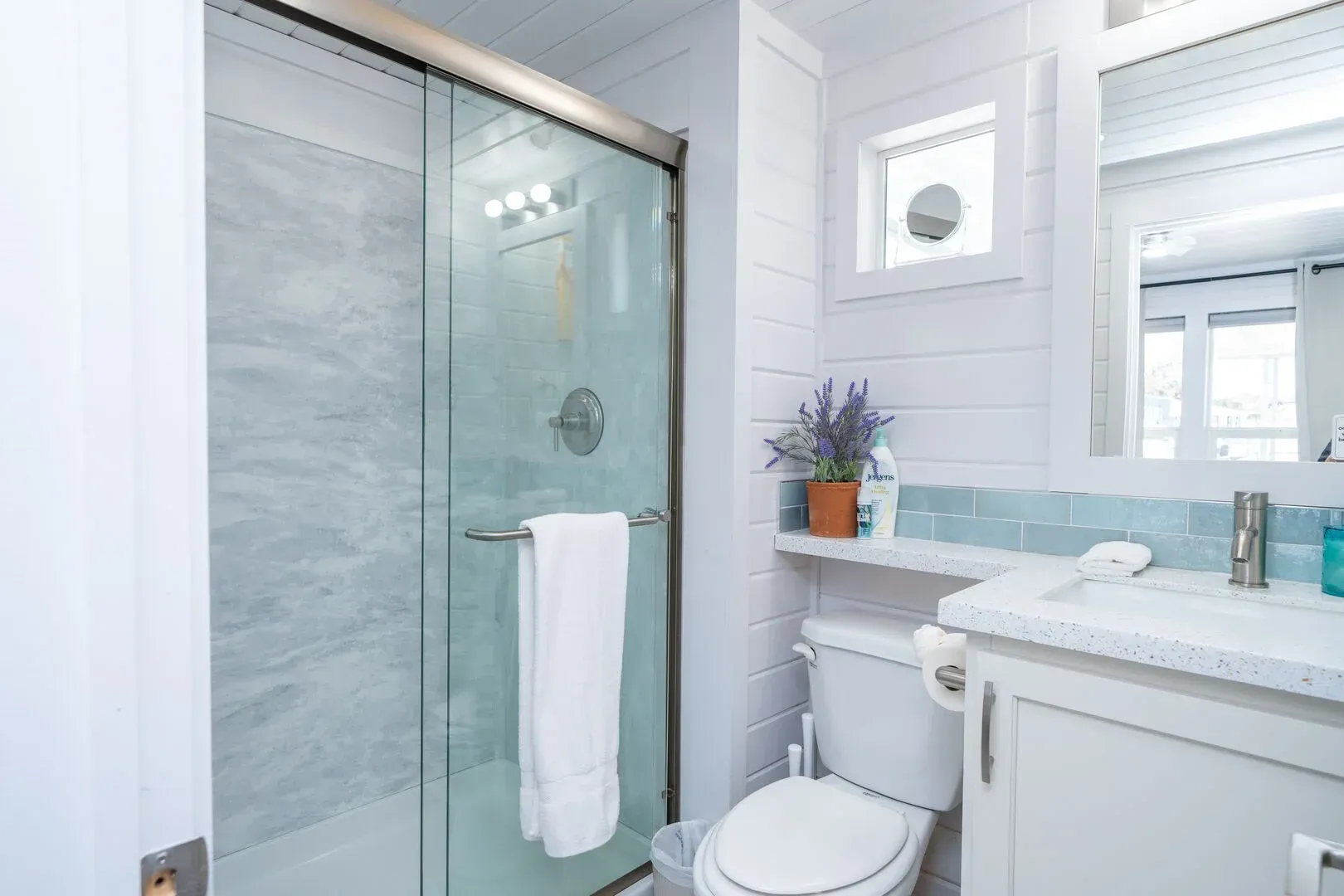 A bathroom with a toilet , sink and shower.