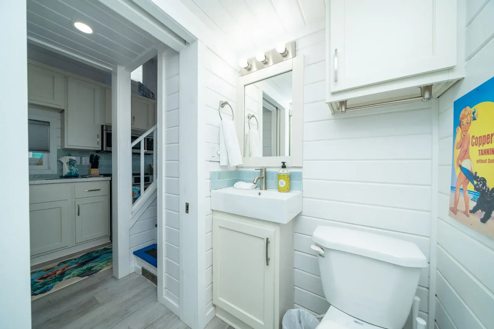 A bathroom with a toilet , sink and mirror.