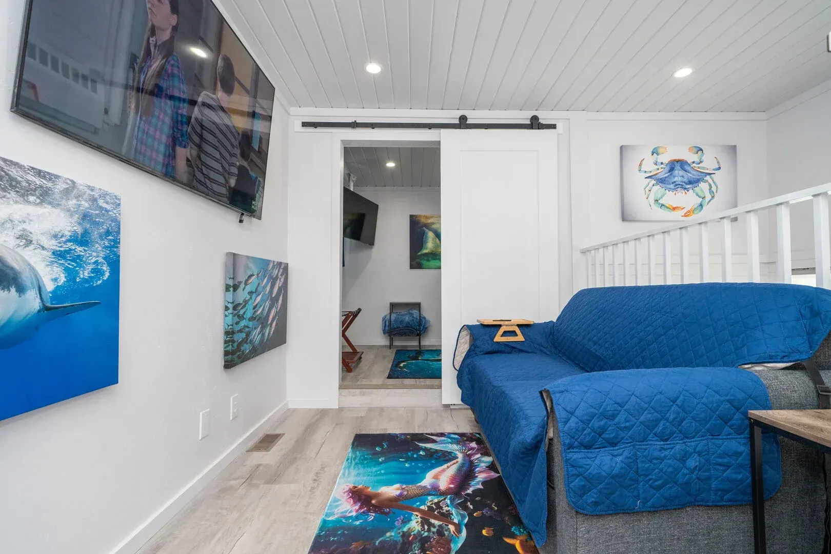 A living room with a blue couch and a flat screen tv.