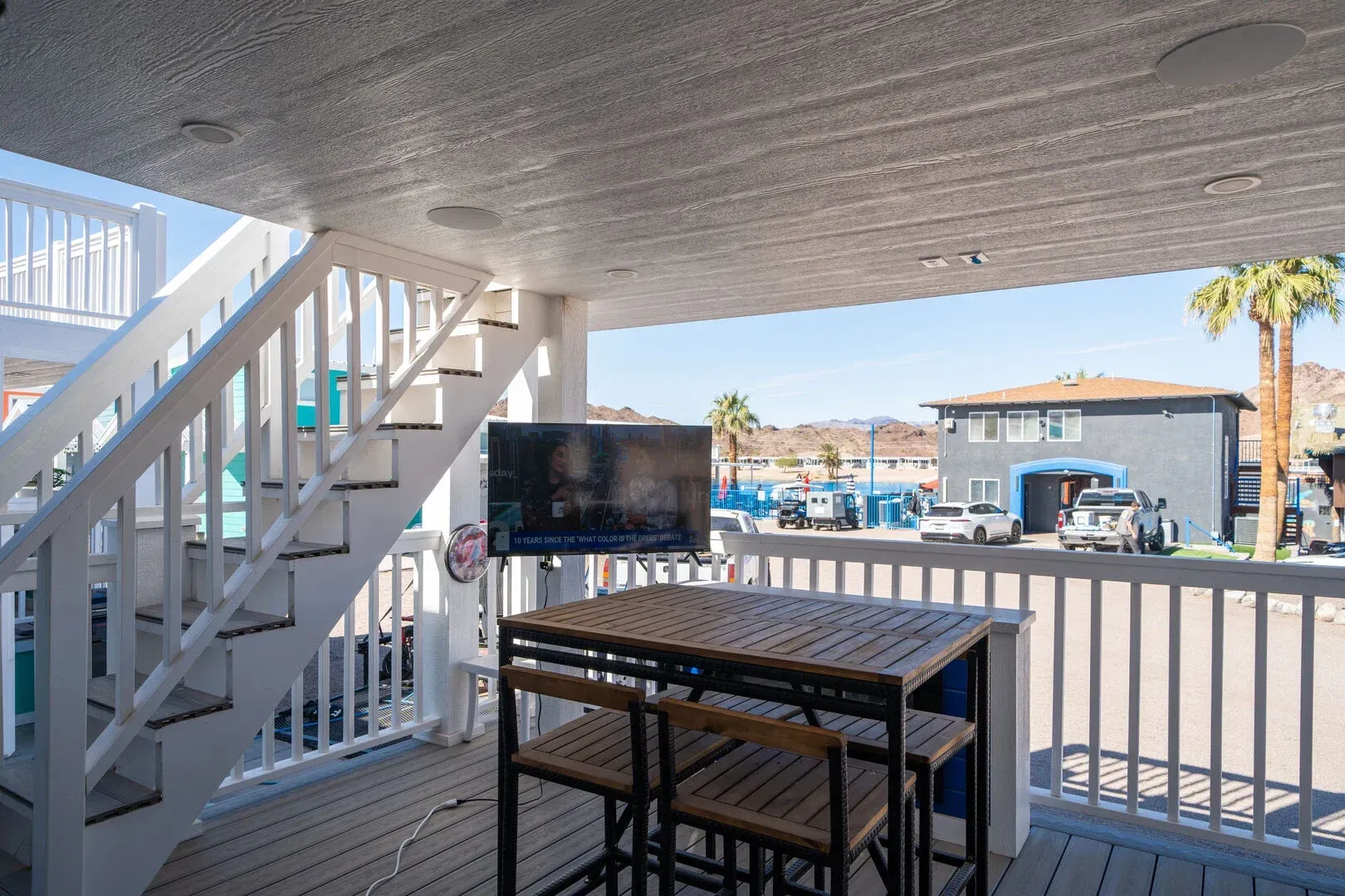 A balcony with a table and chairs and a flat screen tv.