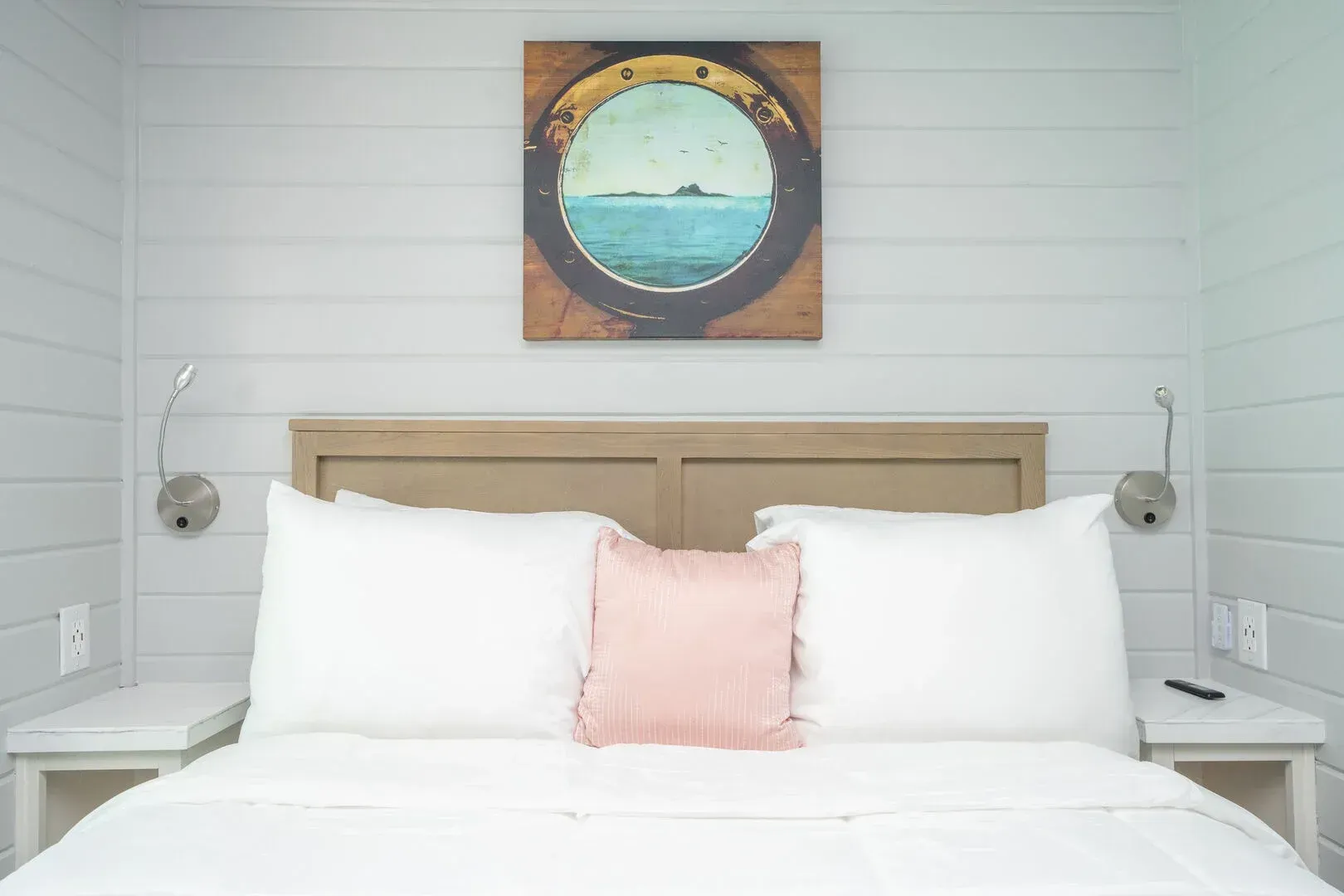 A bedroom with a bed , nightstands , and a painting on the wall above the bed.