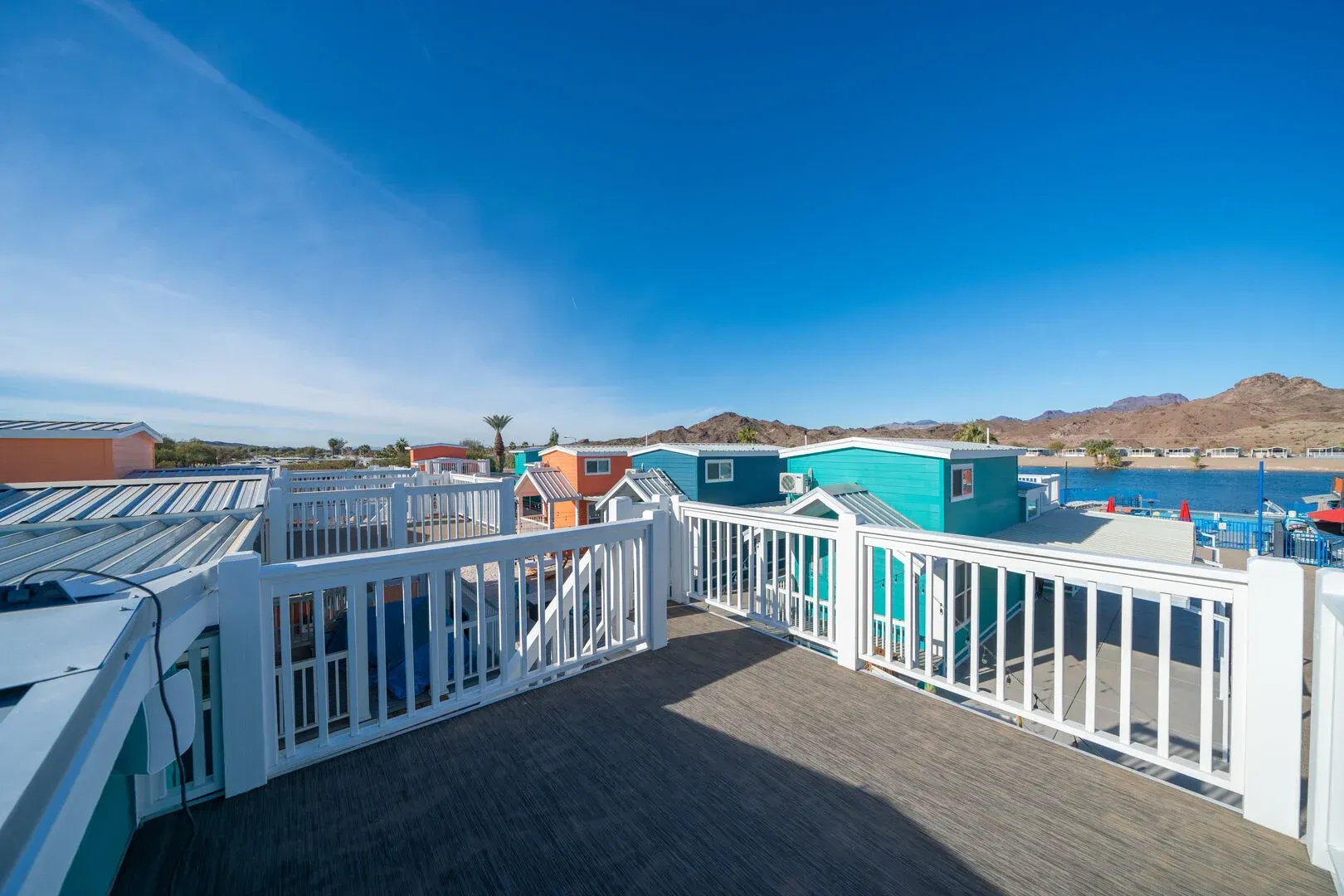 A balcony with a white railing overlooking a body of water.