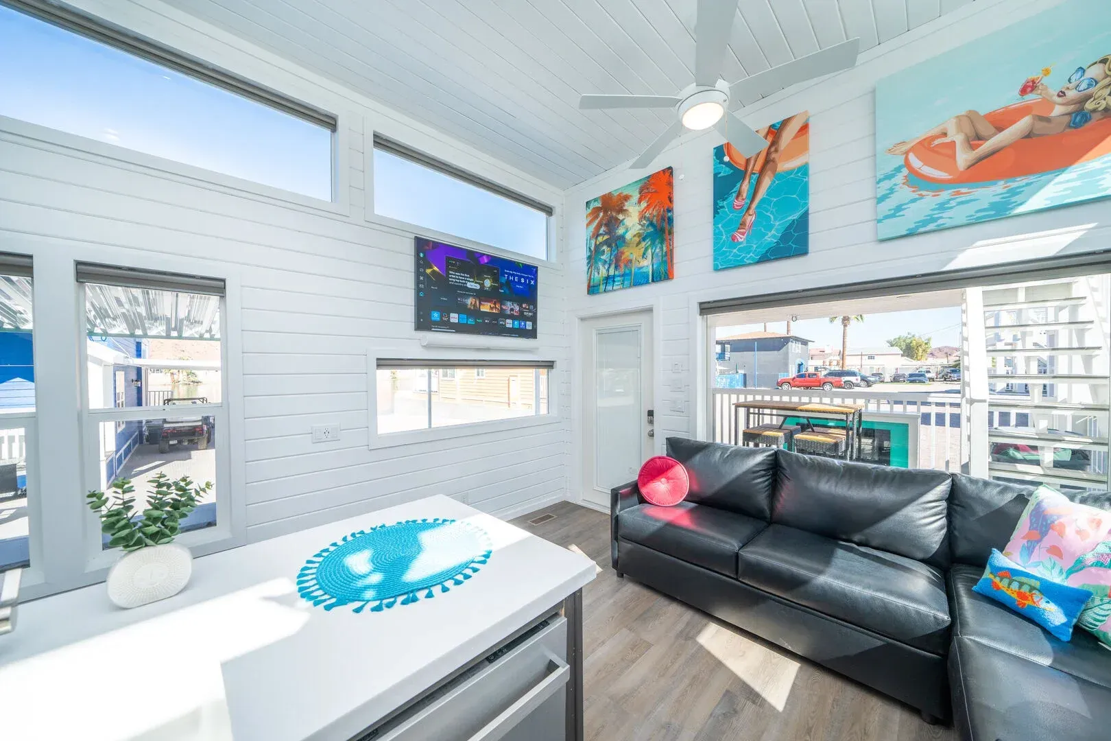 A living room with a couch , table , and paintings on the wall.