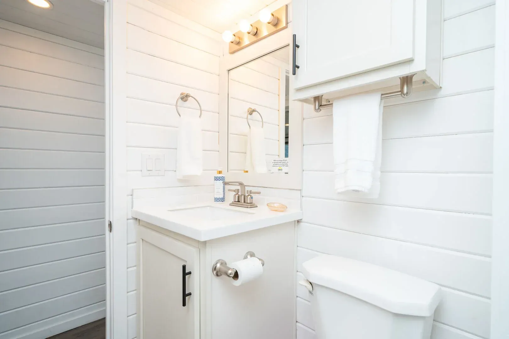 A bathroom with a sink , toilet and mirror.