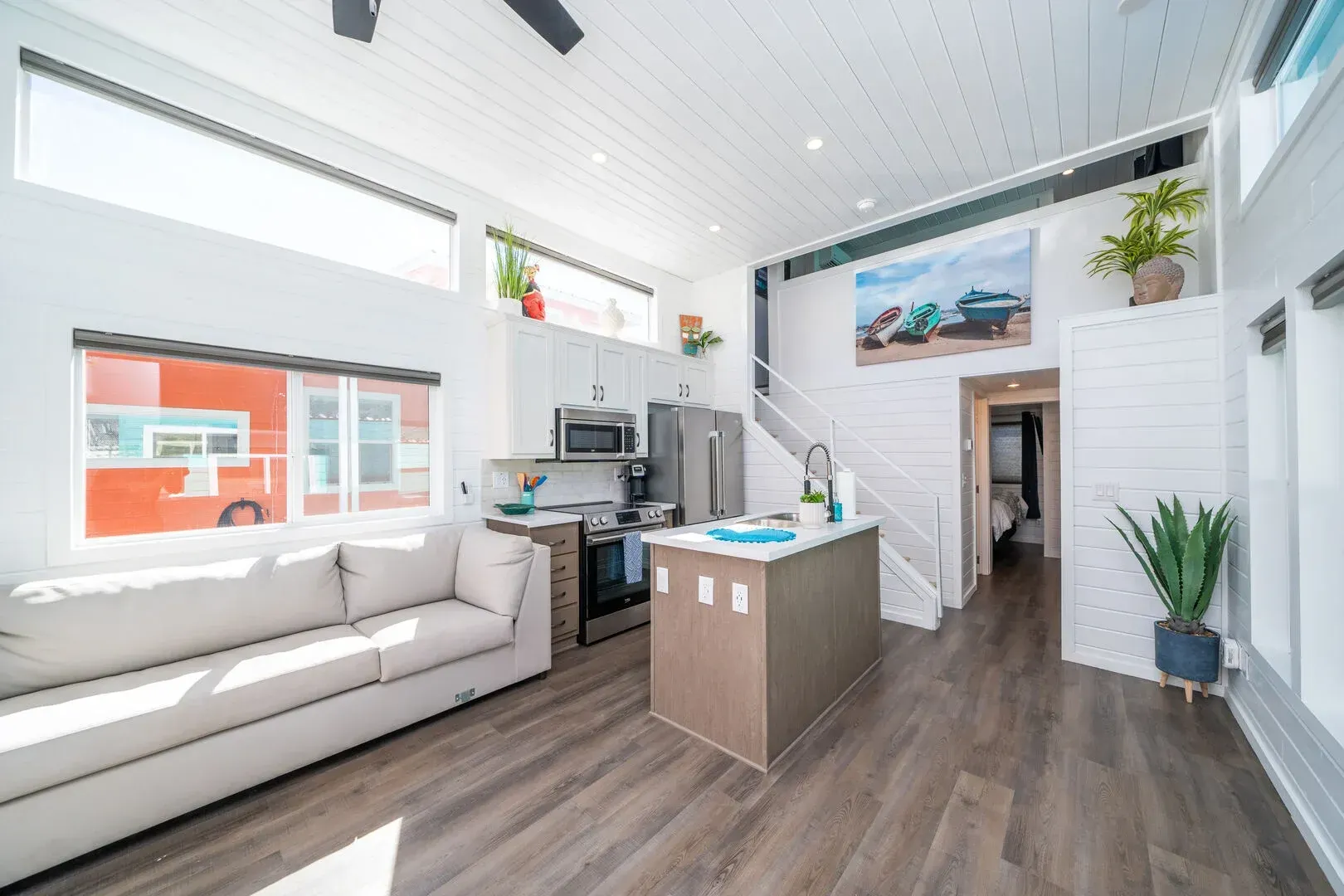 A living room with a couch and a kitchen in a small house.
