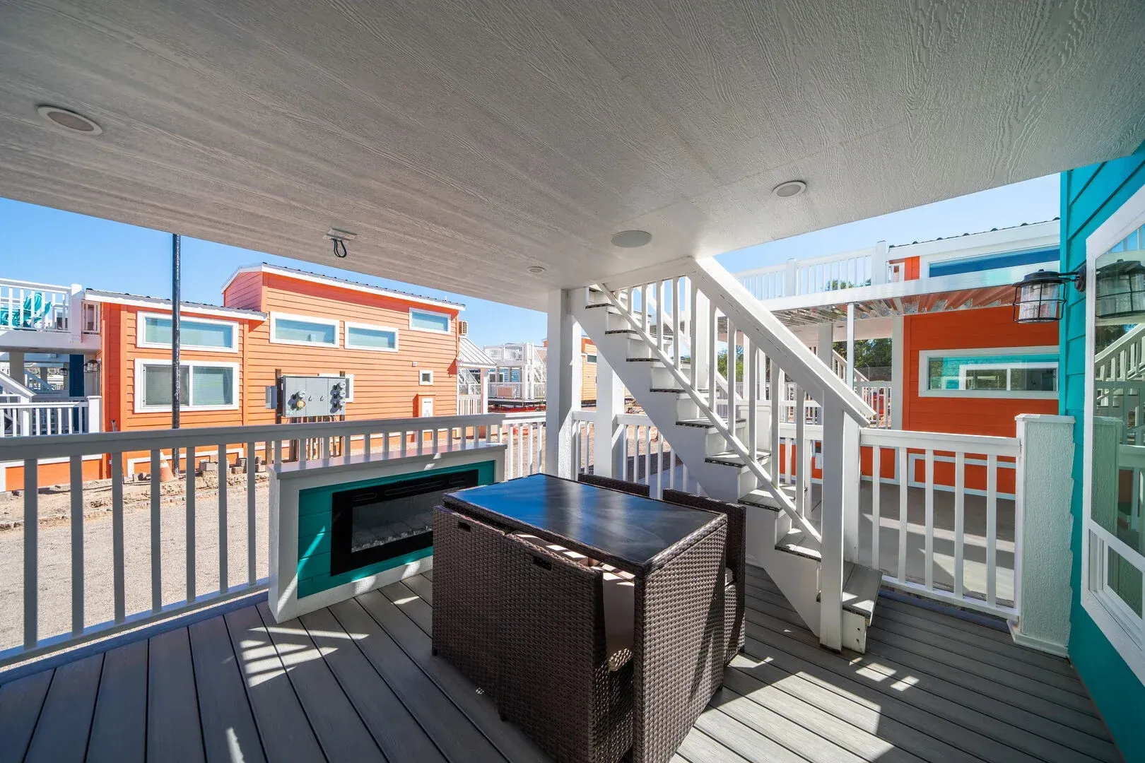 A balcony with a table and chairs and stairs leading up to it.
