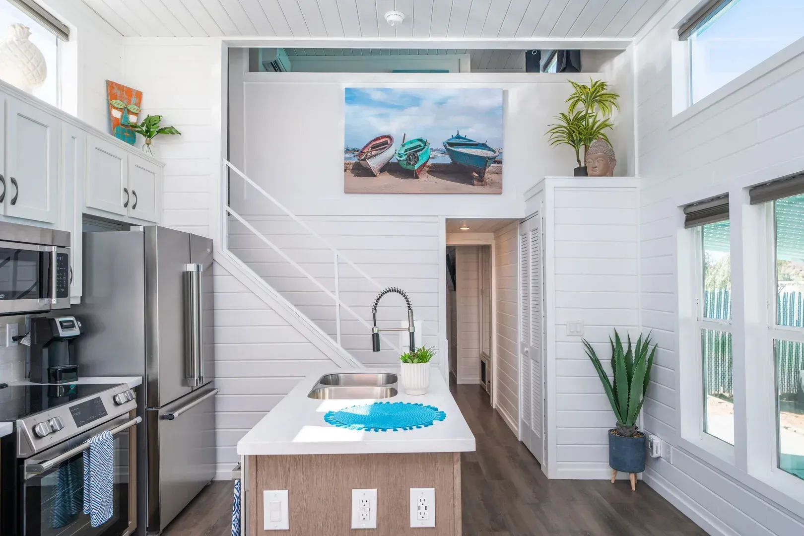A kitchen in a small house with a staircase leading to the second floor.